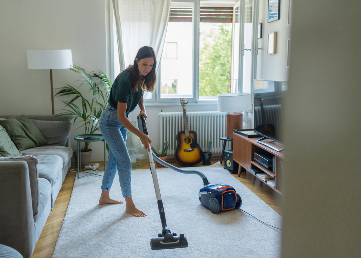 Frau saugt das Wohnzimmer