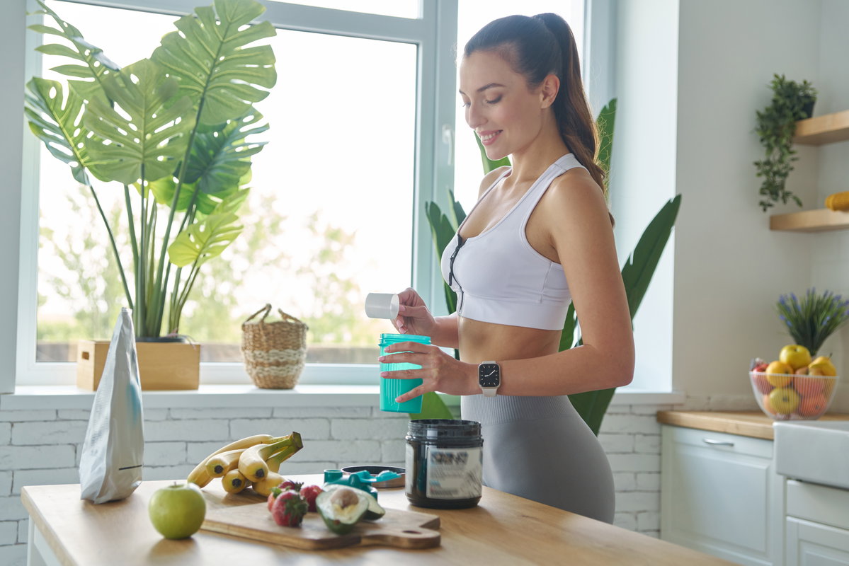 Frau mixt sich Shake nach Sport