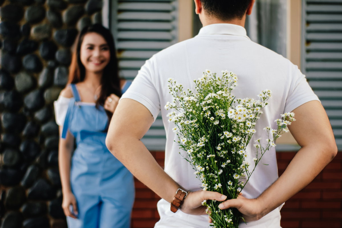 Dating Tipps: Junger Mann hat Blumen für sie