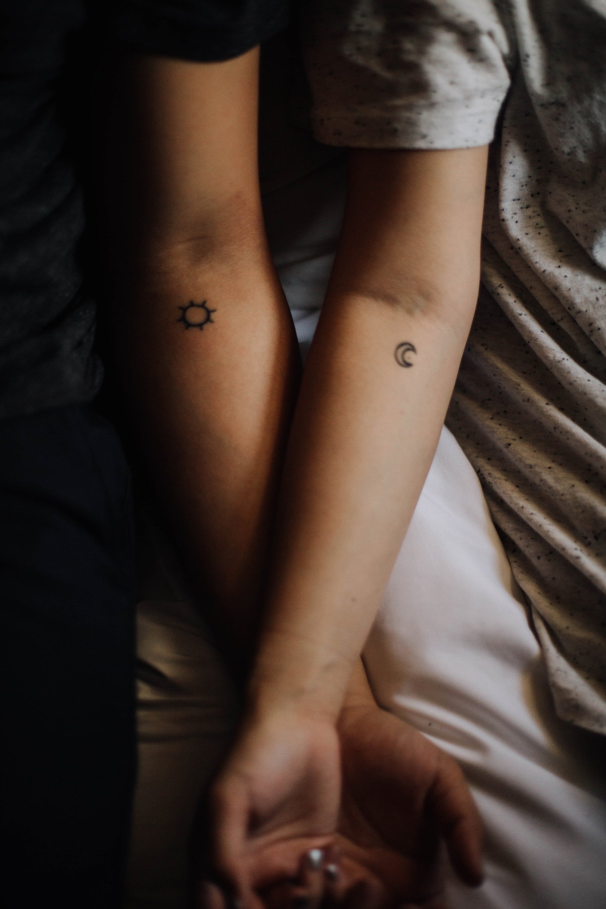 zwei Arme mit kleinen Tattoos Mond und Sonne