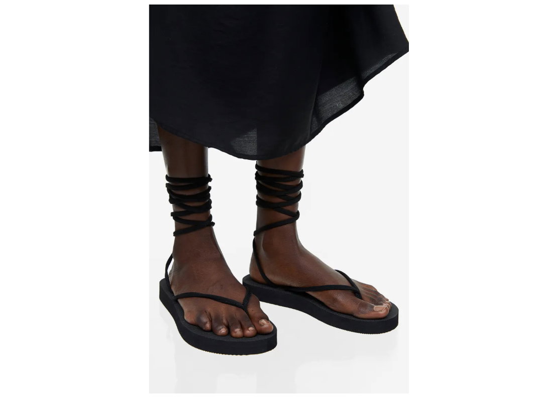 Frau trägt schwarze Sandalen