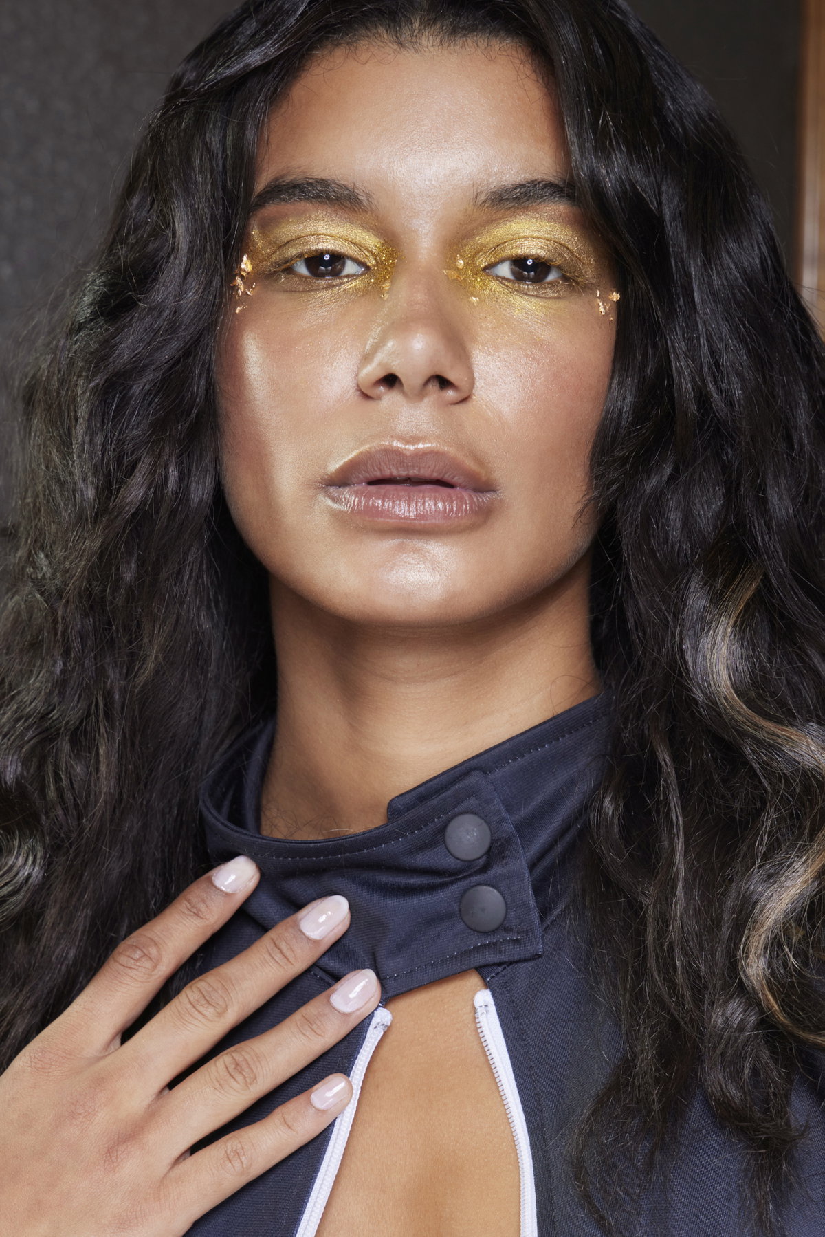 Frau auf Fashion Show von Liberatore trägt goldenen Lidschatten und schlichte Nägel Nagellack Syrup Nails
