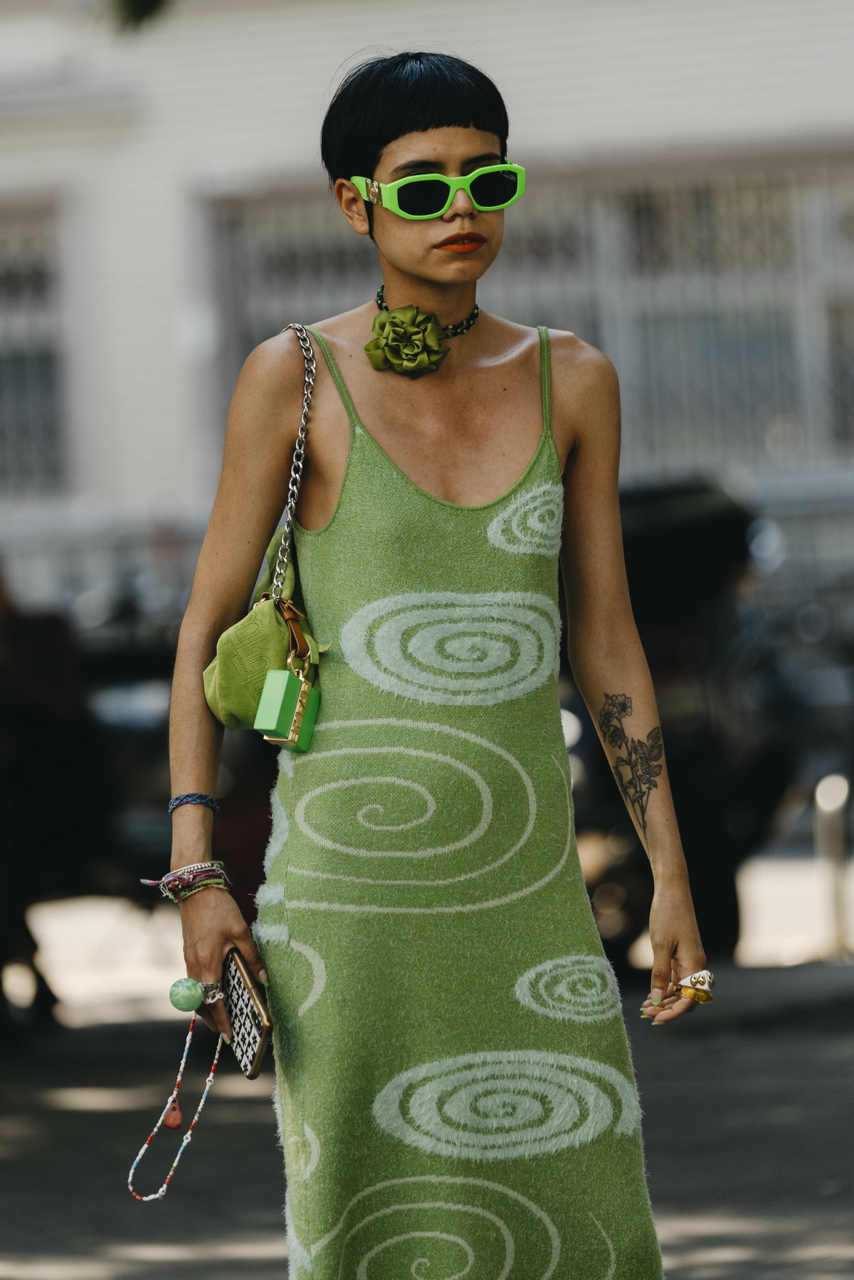 Frau auf Fashion Week trägt grünes Kleid grüne Brille und Micro Pony