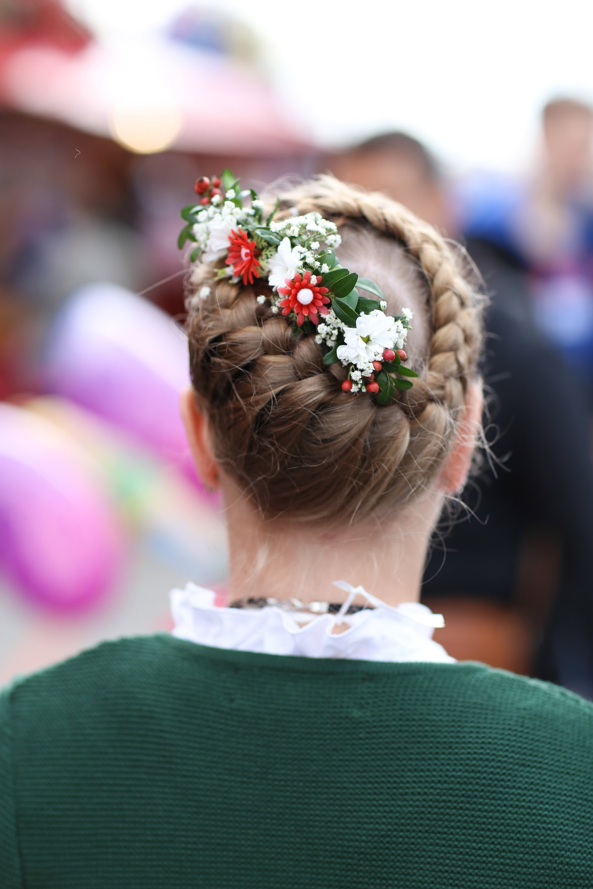 Frau trägt geflochtene Haare mit Blumen Oktoberfest