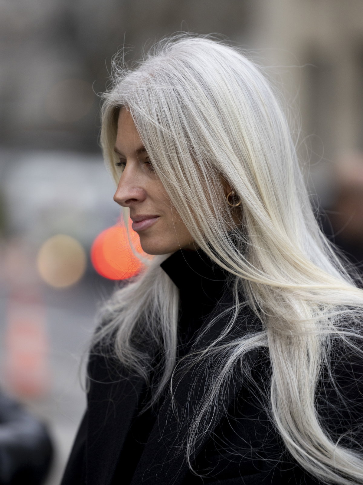 Frau trägt schwarzen Mantel und graue Haare mit Fox Cut