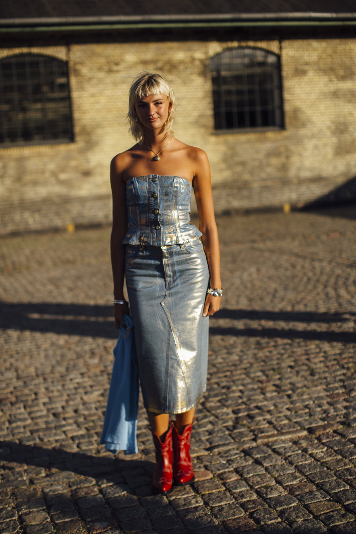 Mia Regan auf Copenhagen Fashion Week trägt metallisches Kleid und rote Boots plus Micro Pony