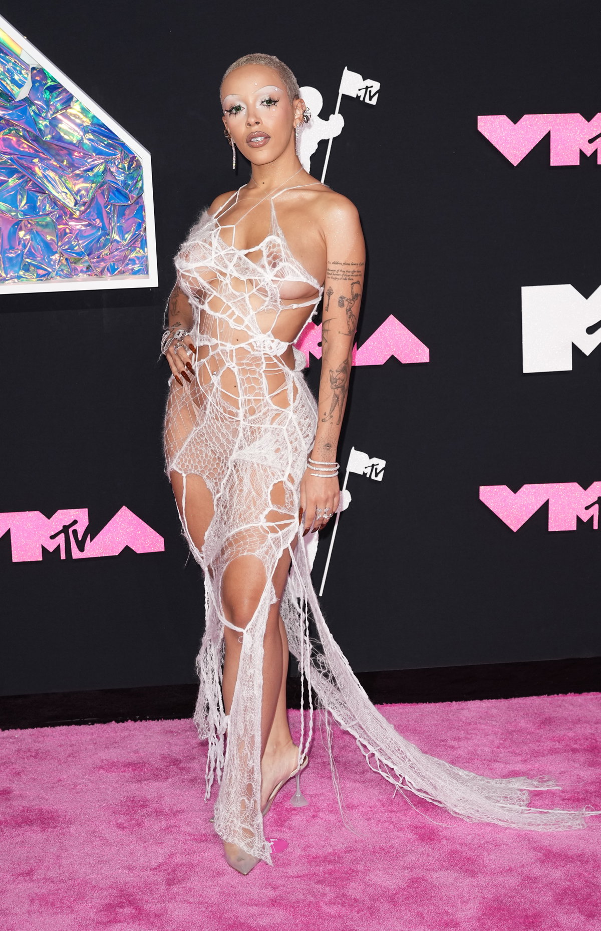 Was ein Look! Bei Sängerin Doja Cat (27) stand alles im Zeichen der Spinne, denn nicht nur das Kleid und die Accessoires bestanden aus Spinnentieren und Spinnennetzen, auch das Make-up hatte die eine oder andere Anspielung auf die Krabbeltiere. Allen voran ihre Wimpern, die sie zusammengeklebt trug und diese mit viel Glitzer und Glitzersteinen auf der Haut kombinierte. Ihre Zähne schmückten ein Dior-Zahn und ihre Augenbrauen waren super-dünn geschminkt.