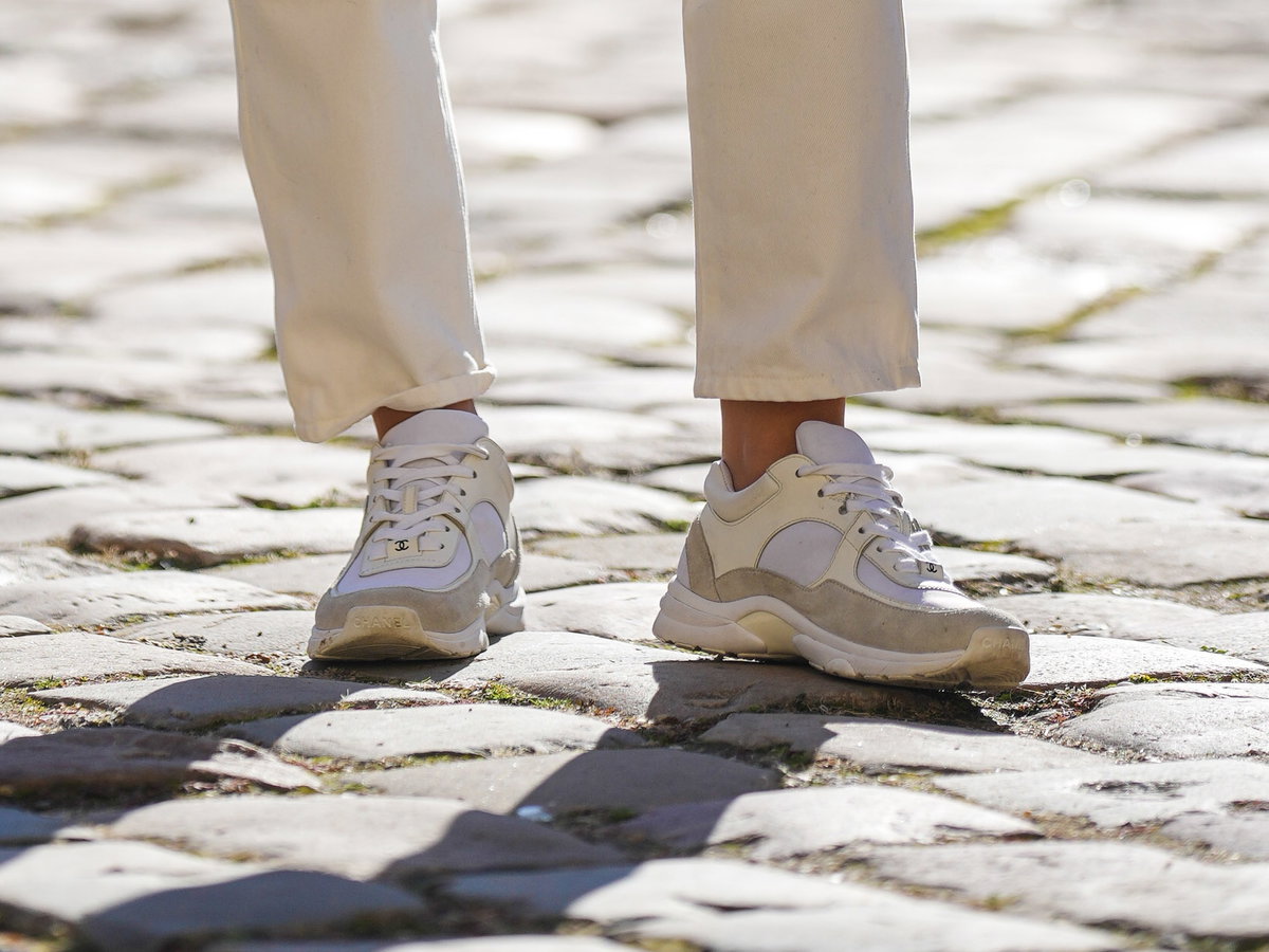 Frau trägt beige-weiße Sneaker mit Plateau-Sohle