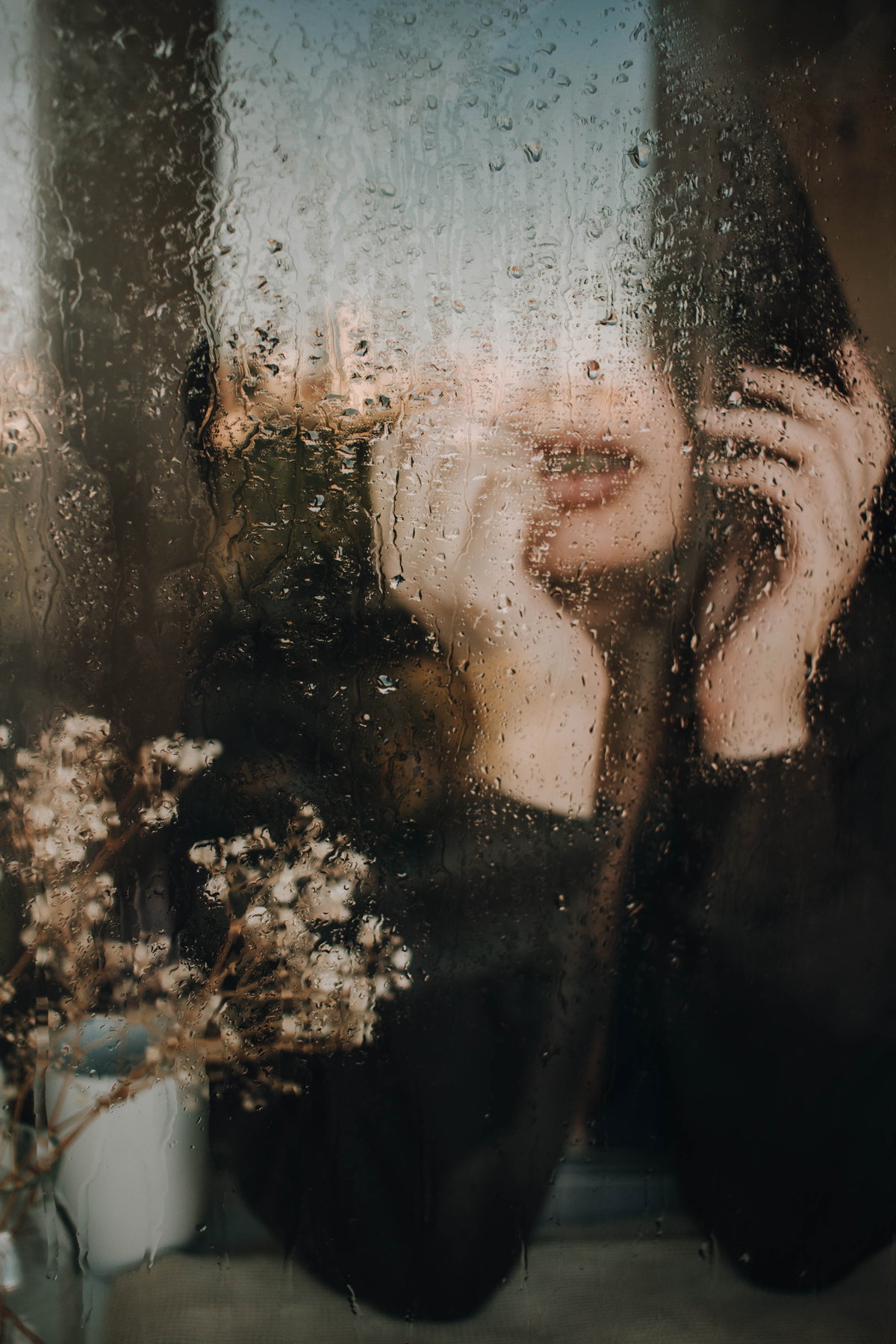 Frau am regnerischen Fenster