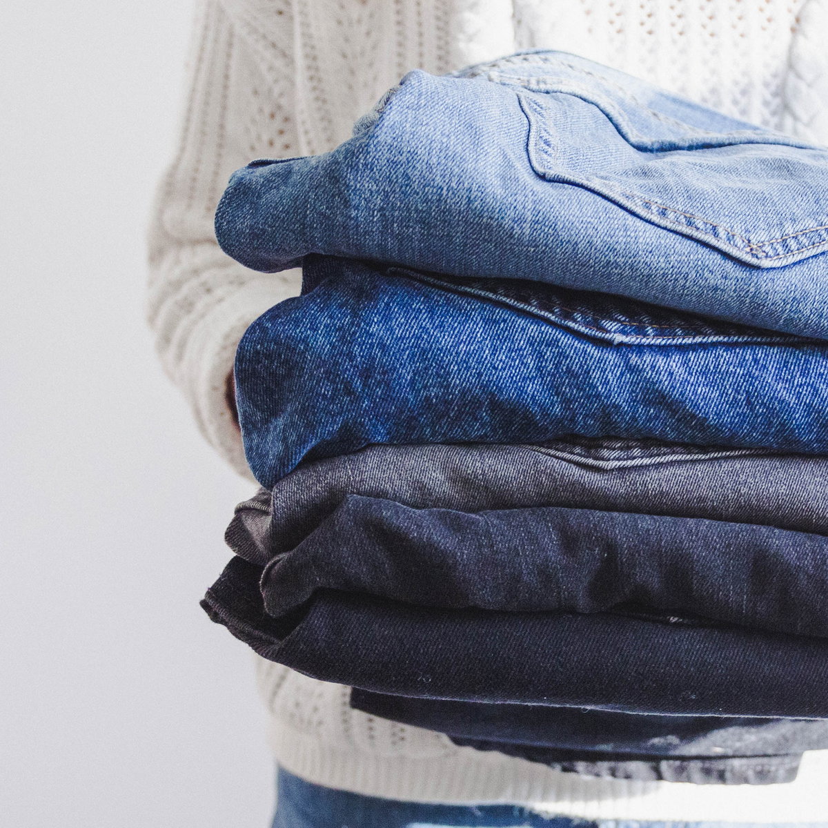 Frau trägt Jeans auf Arm