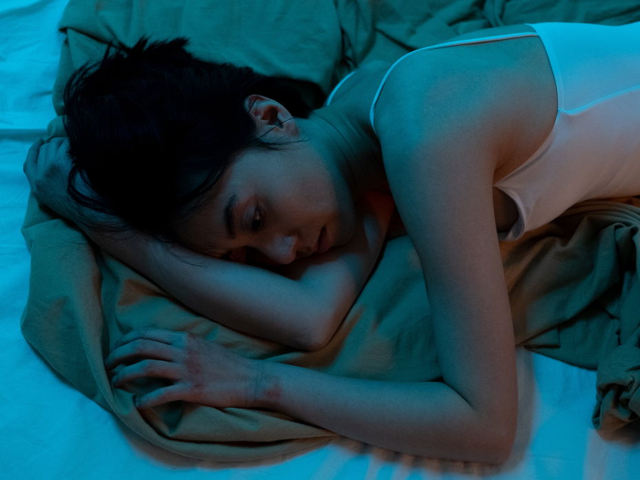 Traurige Frau liegt im Bett