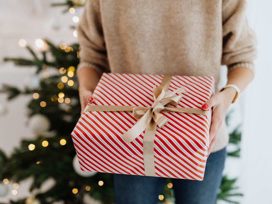 Person mit Geschenk in der Hand