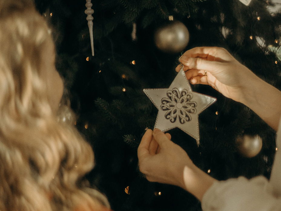Frauen schmücken Weihnachtsbaum mit Stern