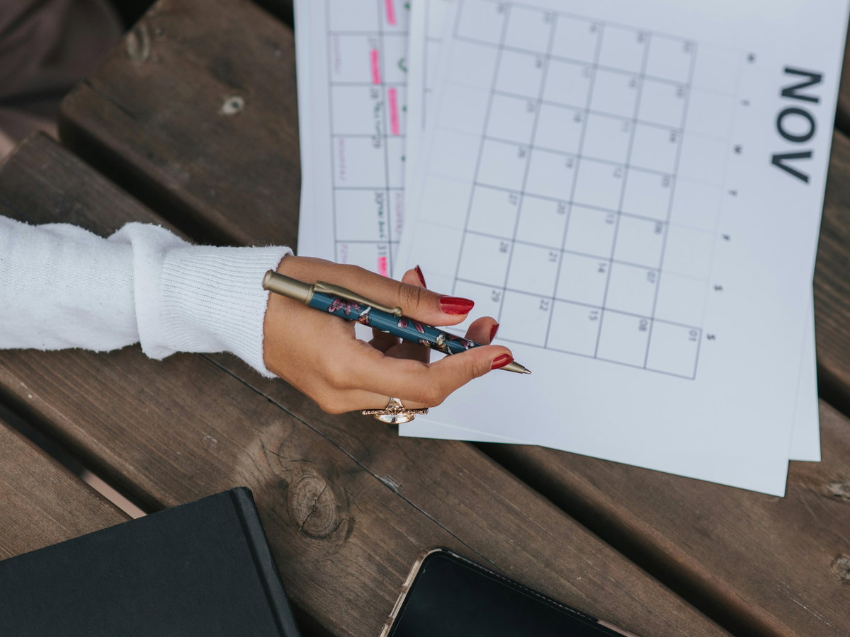 Frau schreibt etwas in den Kalender