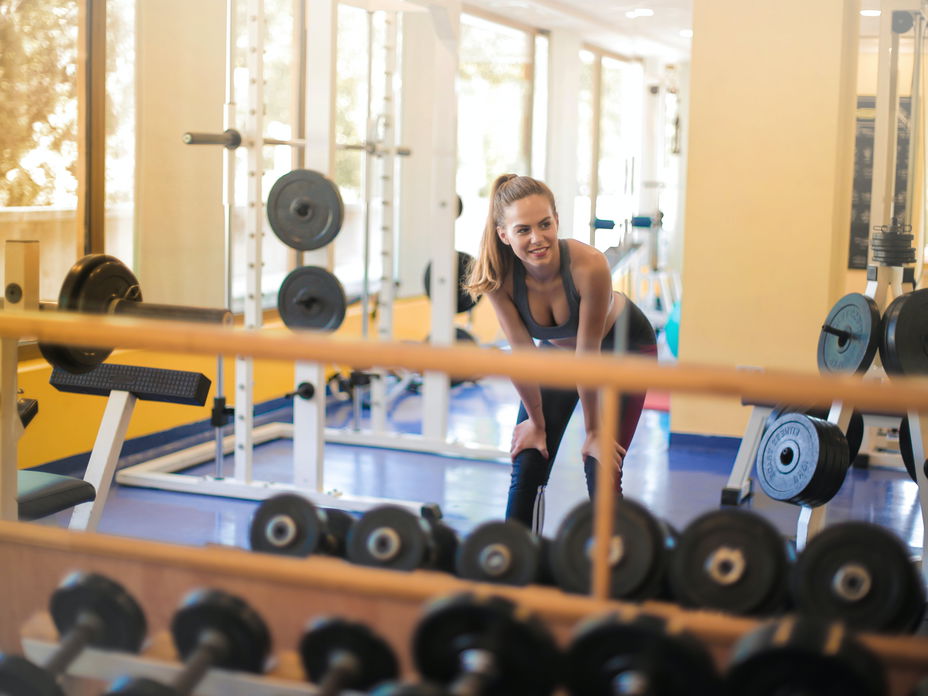 Frau im Fitnessstudio mit Hanteln