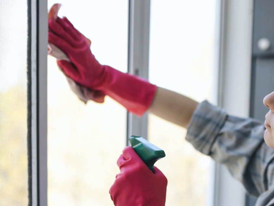 Frau putzt Fenster