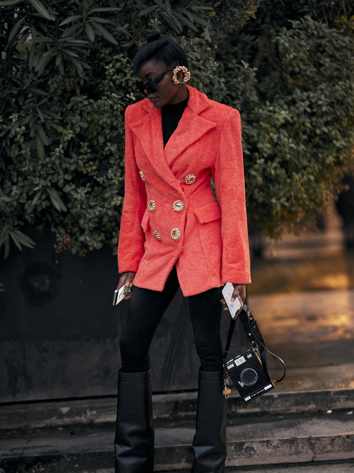 Frau trägt auf Paris Fashion Week kniehohe Stiefel Blazer und blickdichte Strumpfhose