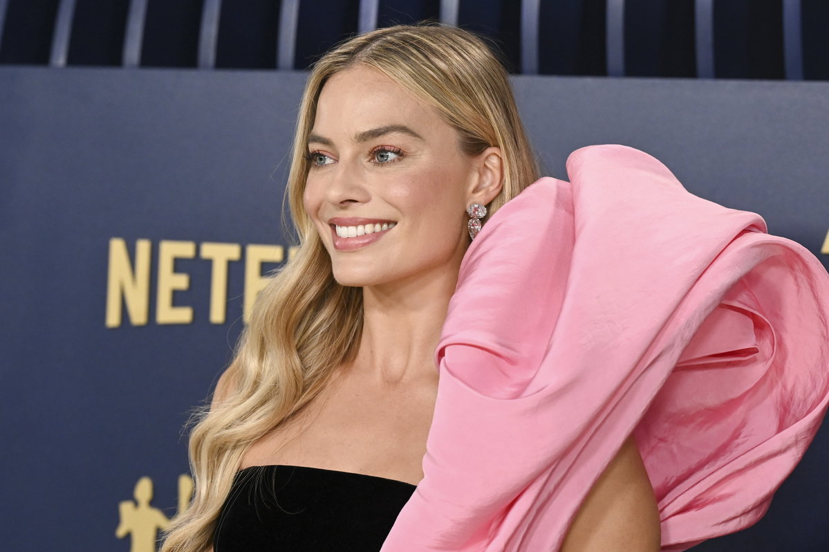 Hallo Barbie! Schauspielerin Margot Robbie nahm das Rosa ihrer Schleppe ihres tollen Kleides in ihrem Augen-Make-up auf und setzte auf einen Kaugummirosa-Lidschatten. Die fließenden, blonden Strandwellen rundeten den Look ab.