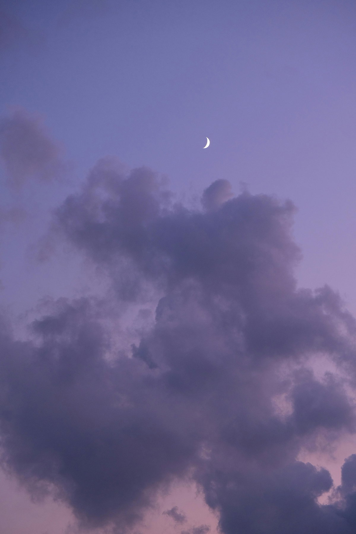 Halbmond am lilafarbenen Himmel mit Wolken