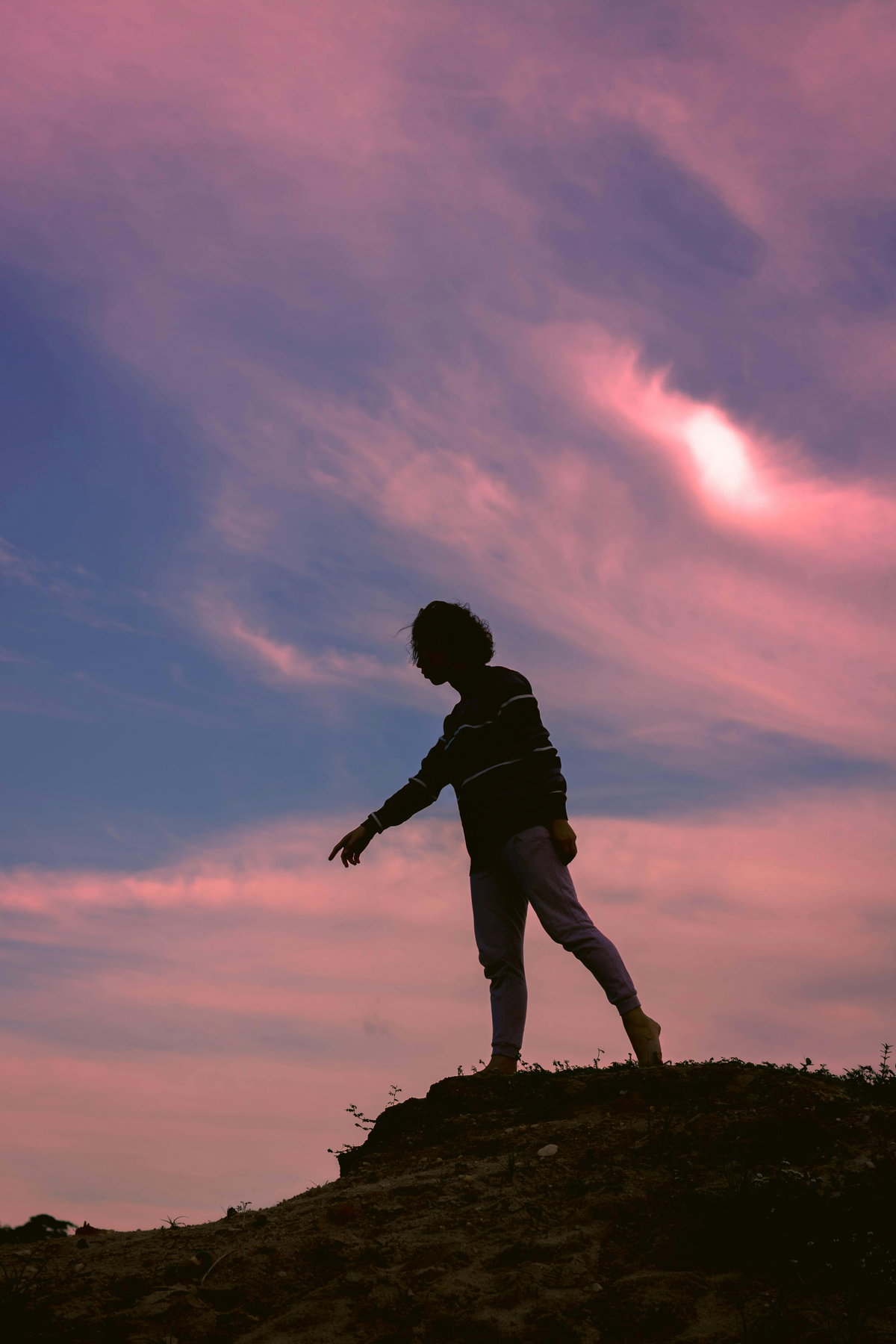 Silhouette einer Frau vor einem rosafarbenen Himmel