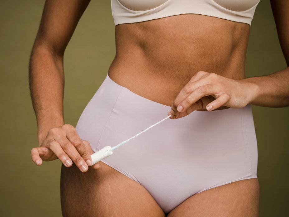 Frau mit Periodenunterwäsche und Tampon in der Hand