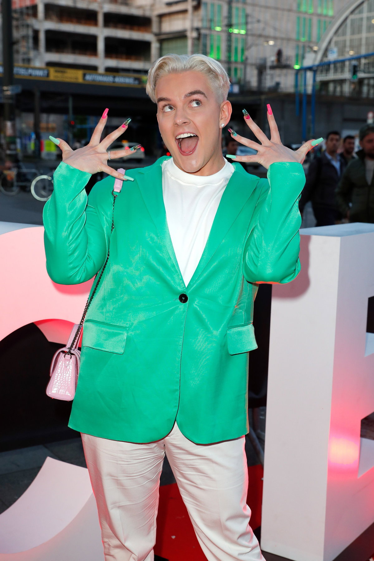 Twenty4Tim mit grünem Blazer und blonden Haaren