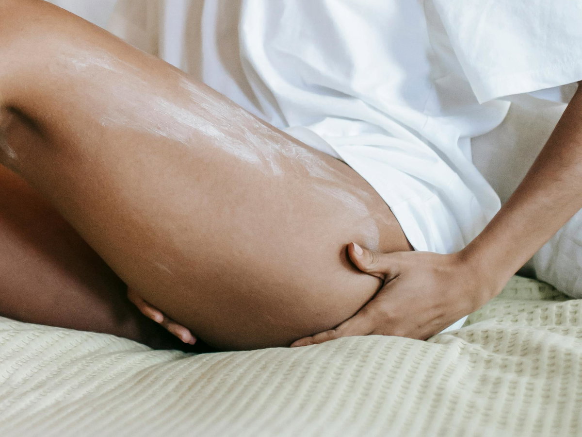 Frau trägt Bodylotion auf