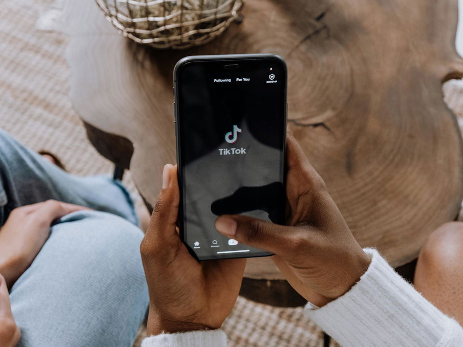 Frau hält Handy mit der TikTok App