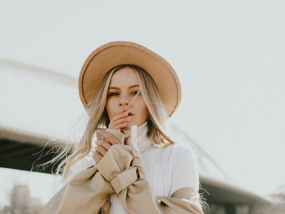 Frau mit Hut und Trenchcoat