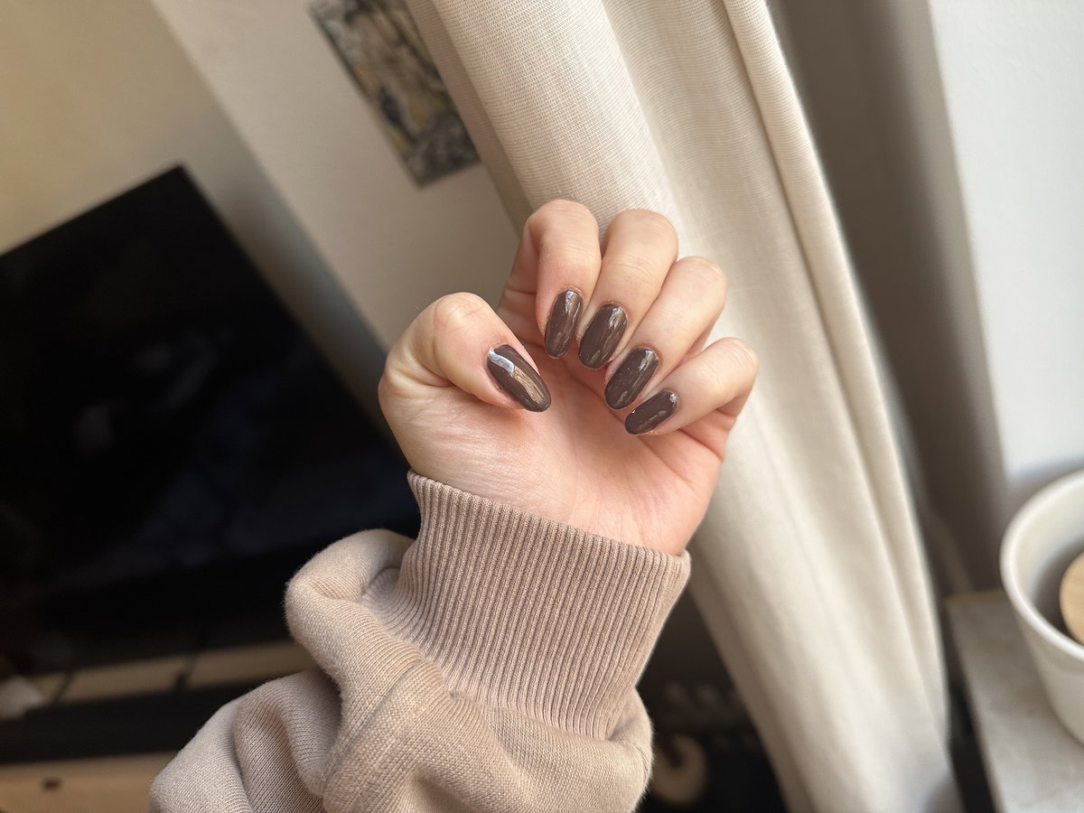 Brauner Nagellack auf den Fingern.