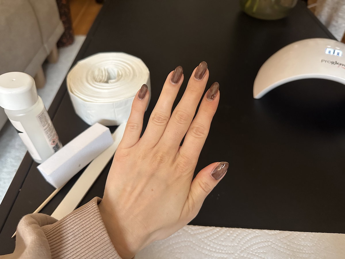 Brauner Nagellack auf den Fingernägeln mit einer Schicht.