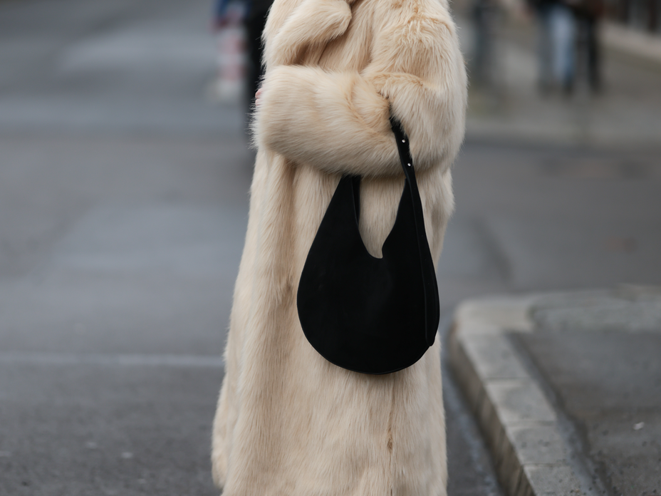 Frau in dickem Fellmantel mit großer Slouchy Bag