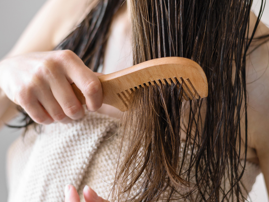 Frau kämmt nasses Haar
