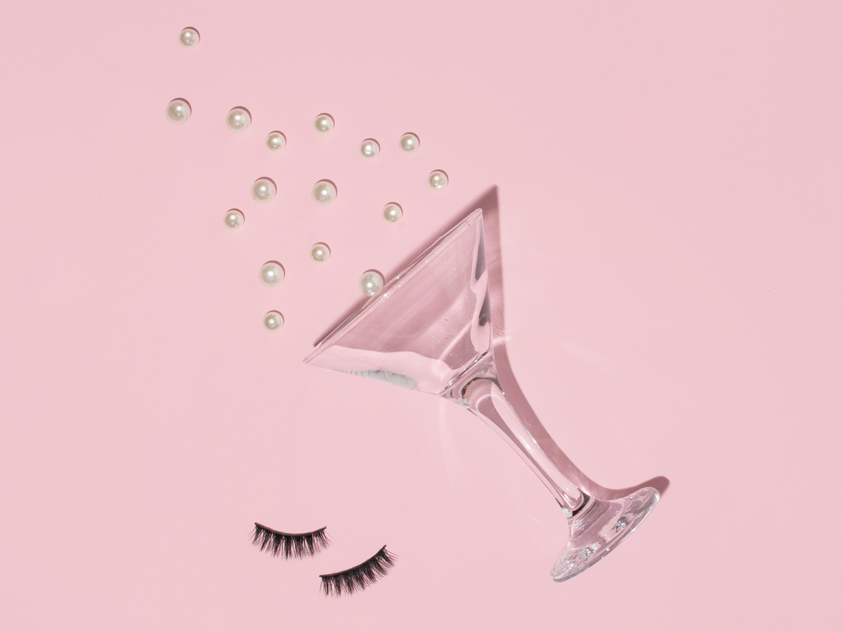 Cocktailglas und Fake Lashes