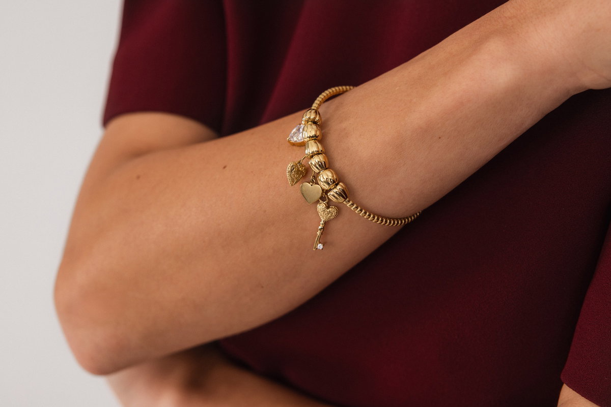 Frau mit einem goldenen Armband mit Charms.