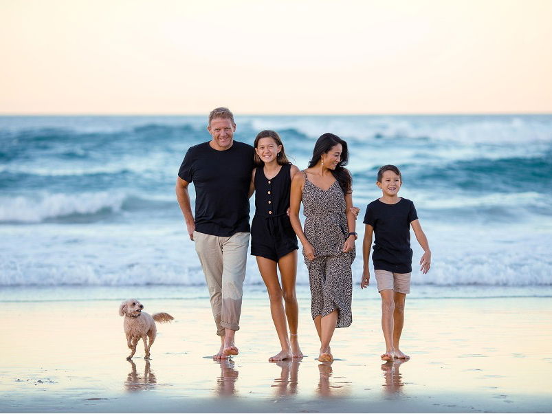 Eine Familie läuft am Strand entlang