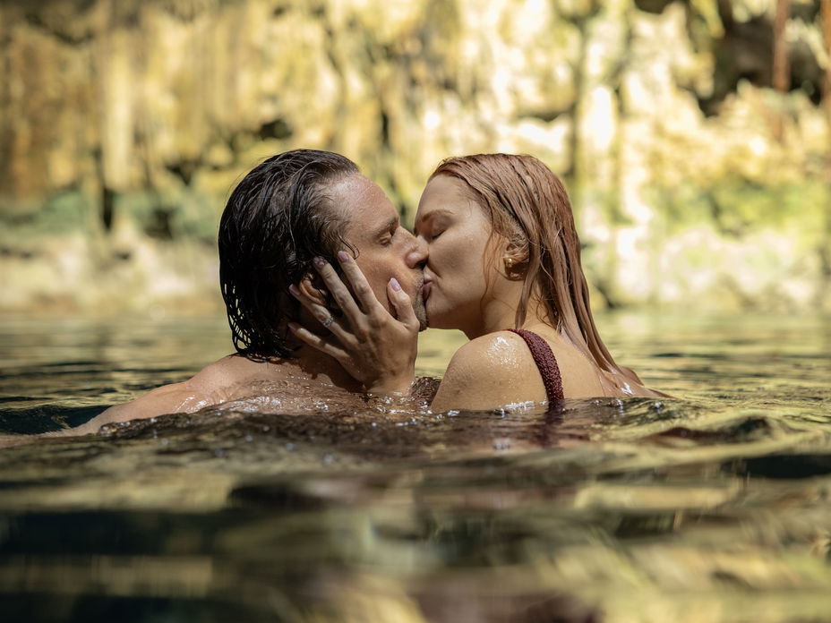 Ein Mann und eine Frau schwimmen im Wasser und küssen sich.