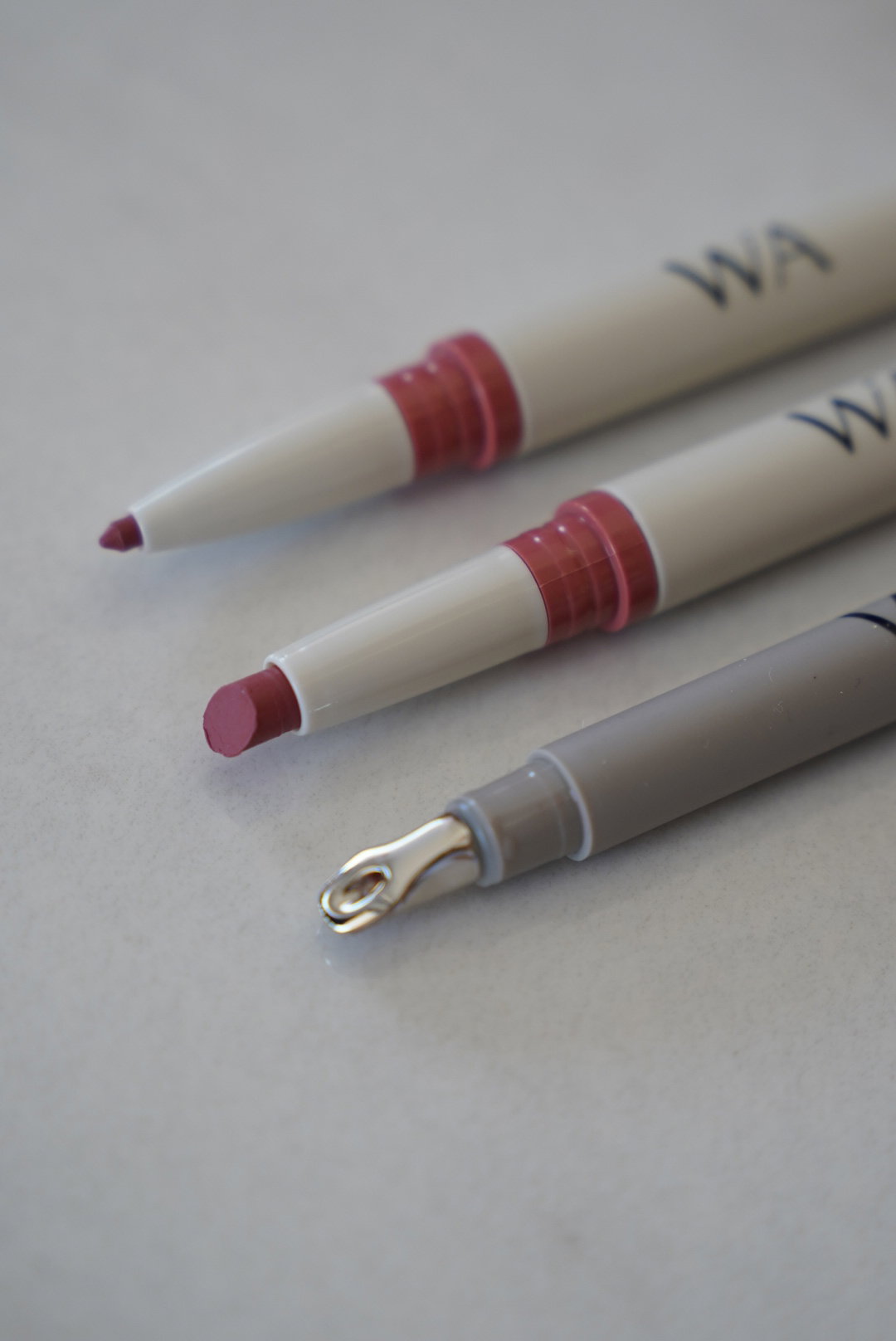 Lippenstift, Lipliner und Lipgloss liegen nebeneinander.