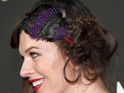 Milla Jovovich mit Federschmuck im Haar